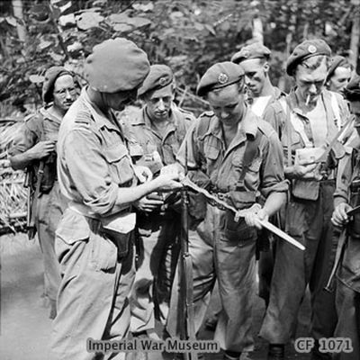 Click to view full size image
 ============== 
British troops in Surabaya studying a Kris.
Keywords: BoS45 Kris
