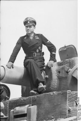 Click to view full size image
 ============== 
German Waffen-SS Obersturmführer Michael Wittmann on a Tiger I heavy tank, Northern France, May 1944, photo 2 of 2.

Source: German Federal Archive
